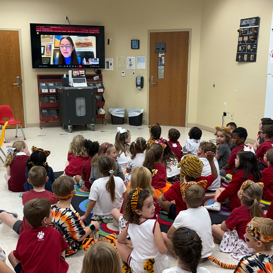 Lower school students watching a video call with teacher.